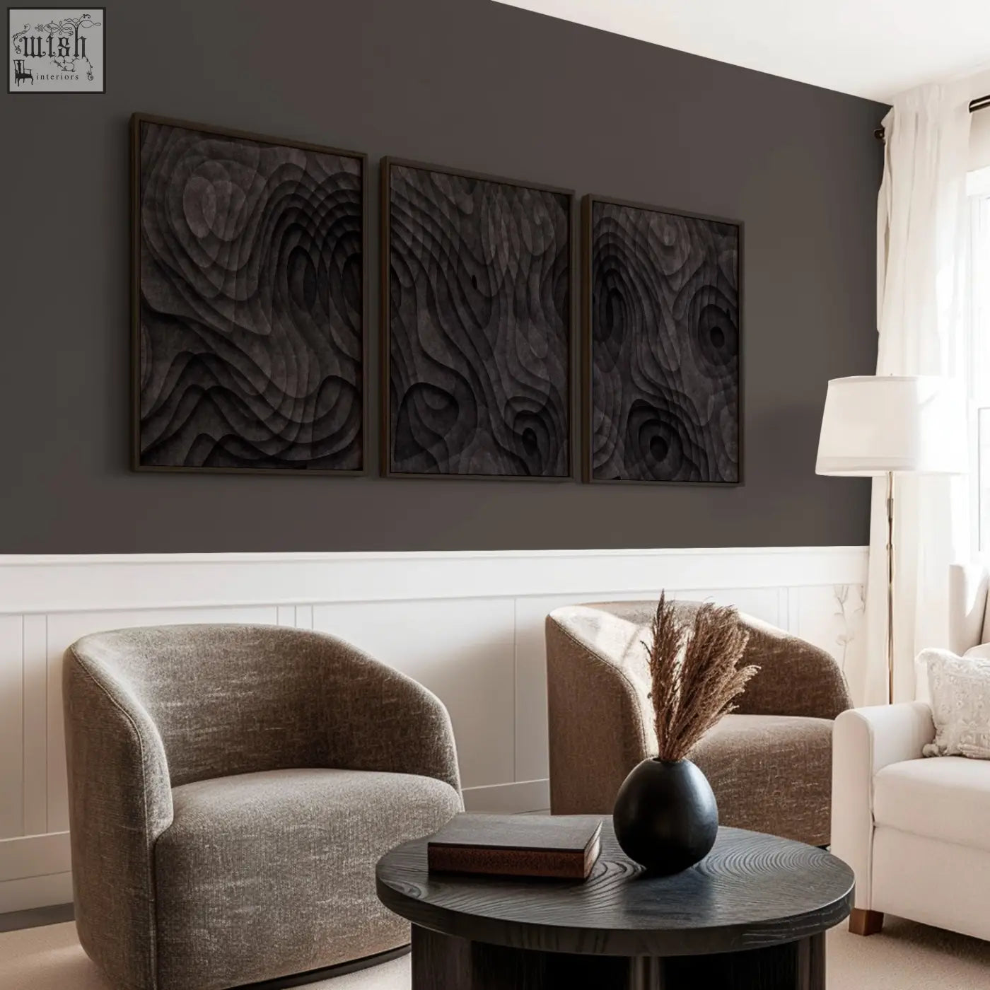 Black matte ceramic vase with dried pampas grass beside minimalist art prints in dark charcoal tones