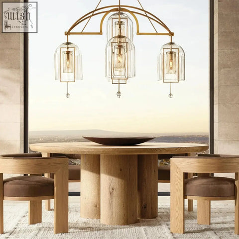 Gold-toned chandelier with clear glass pendant shades and exposed filament bulbs complements the miran chair design