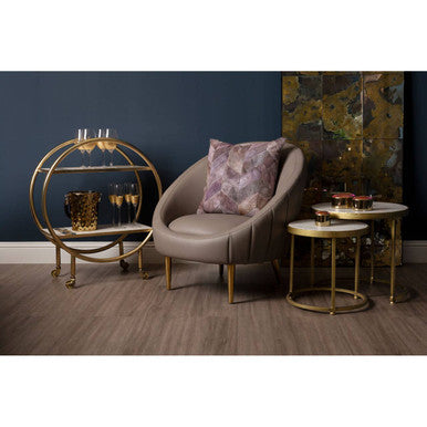 Beige upholstered armchair with small gold metal legs and a patterned lavender cushion for miressa small gold party bucket