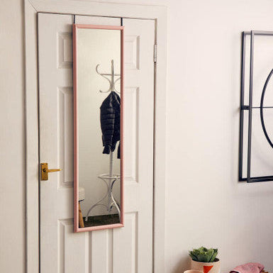 A sleek full-length mize pink plastic frame over door mirror with a delicate pink plastic frame hanging on a white door