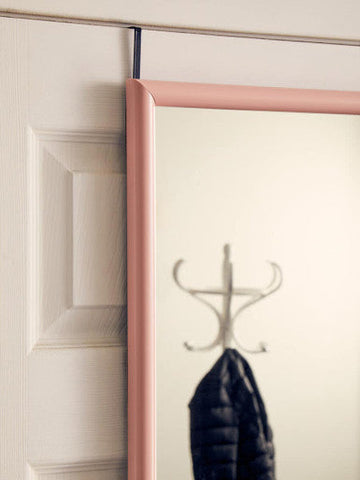 A sleek mize pink plastic frame over door mirror with a minimalist rose gold frame hanging on a white door