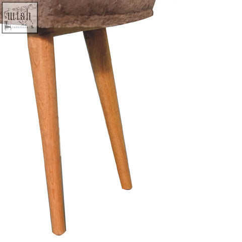 A cozy taupe velvet chair with slender light wood legs perfect for mocha faux fur inspired setups