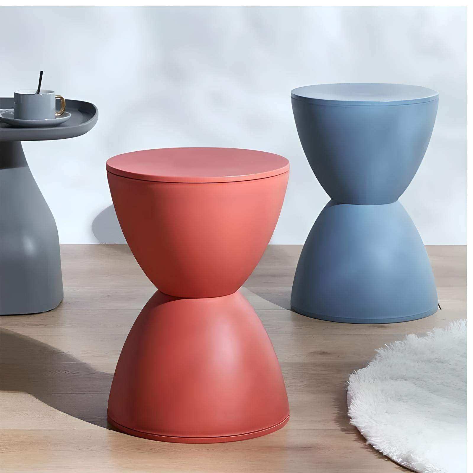 A sleek coral moda hourglass stool with a smooth matte finish and hourglass silhouette perfect for modern spaces