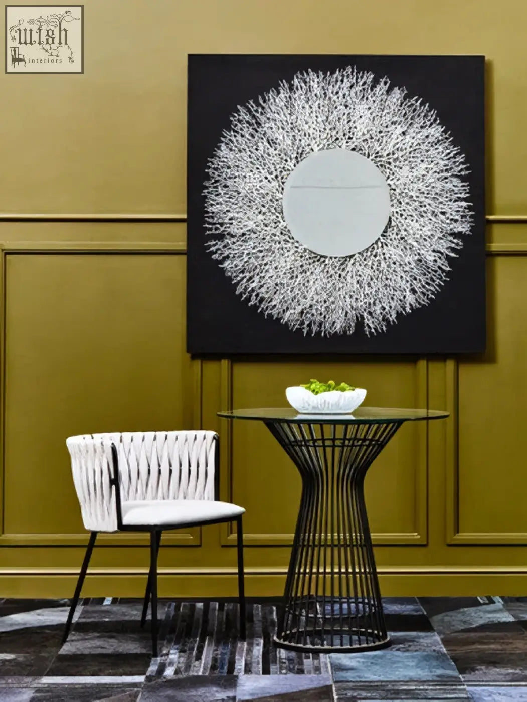 Black wireframe table with glass top and slender geometric legs paired with modello abstract mirrored wall art