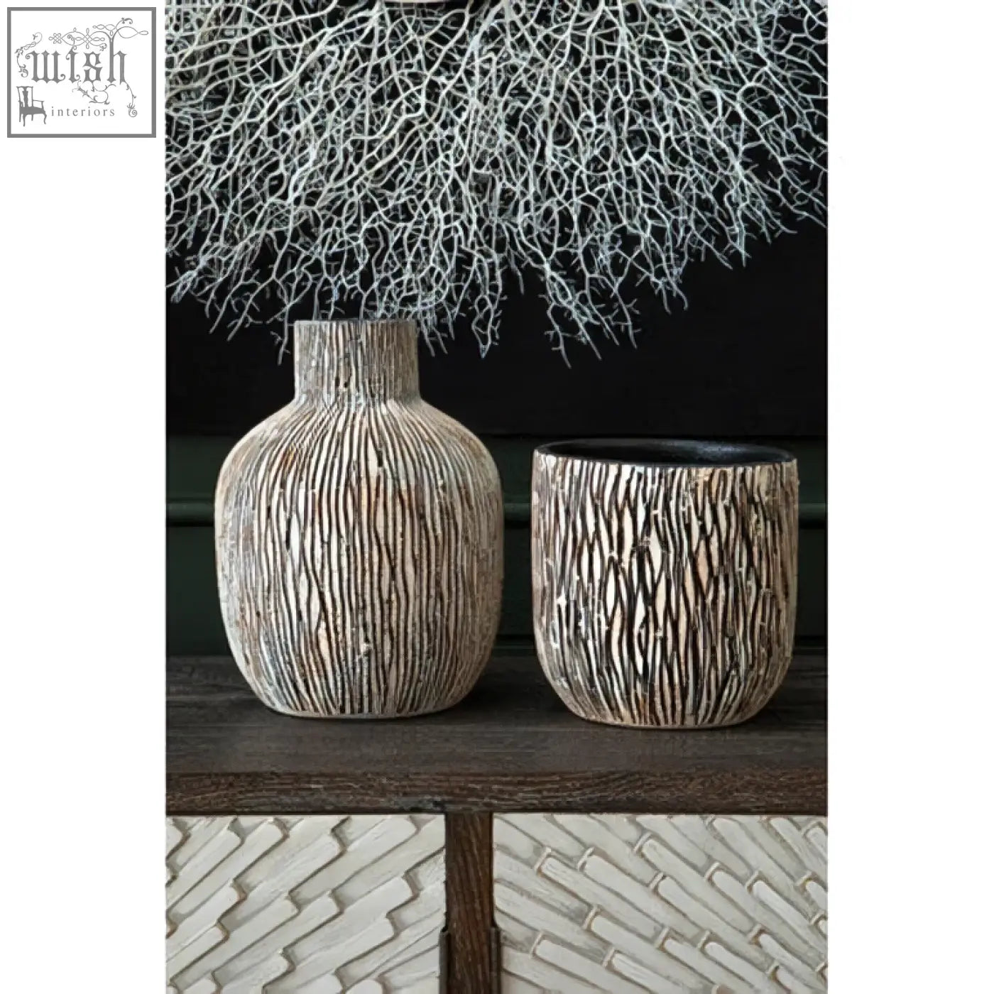 Two textured ceramic vases with ribbed surface and black interior complementing modello abstract mirrored wall art