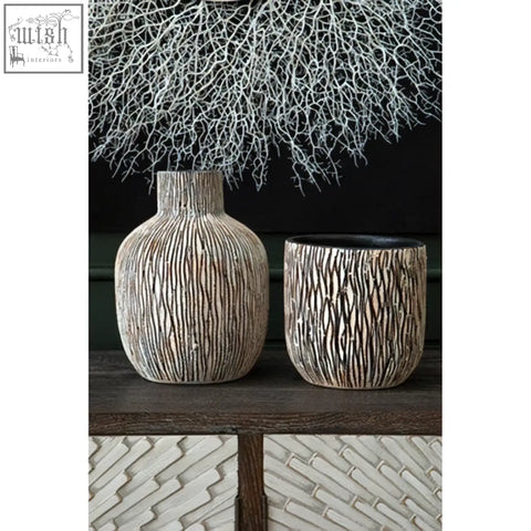 Two textured ceramic vases with ribbed surface and black interior complementing modello abstract mirrored wall art