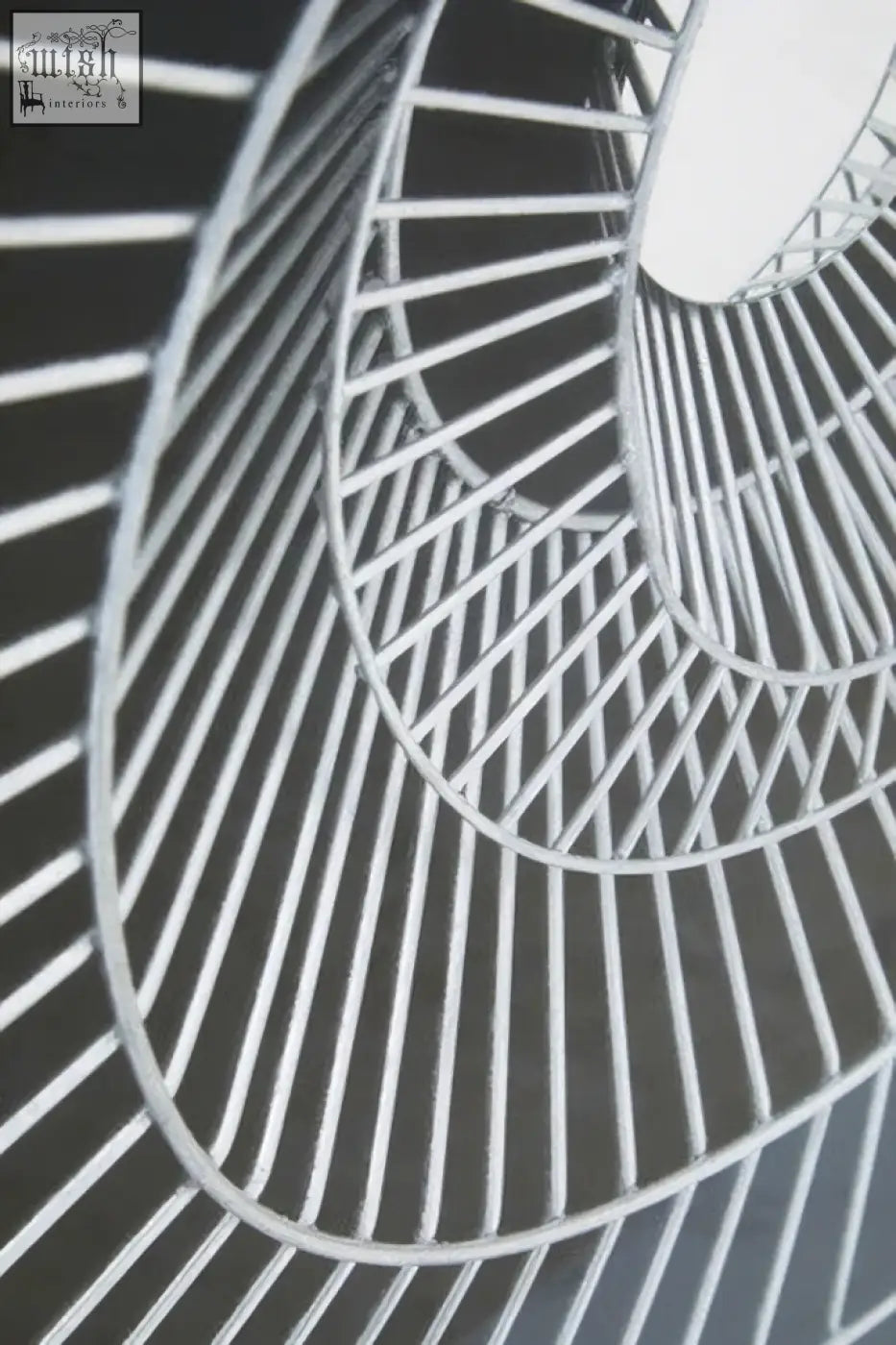 A sleek silver-toned metal spiral staircase wall art with modern geometric design perfect as a black wall art focal point