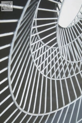 A sleek silver-toned metal spiral staircase wall art with modern geometric design perfect as a black wall art focal point