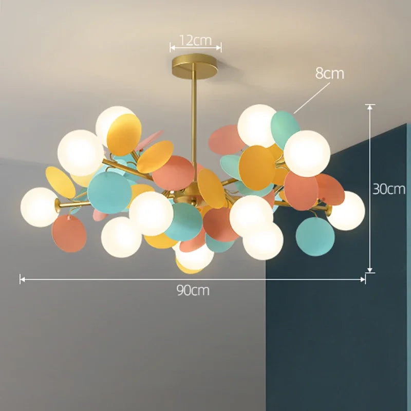 A modern led chandelier with brass finish and colorful glass orbs in white yellow teal and coral as a light source