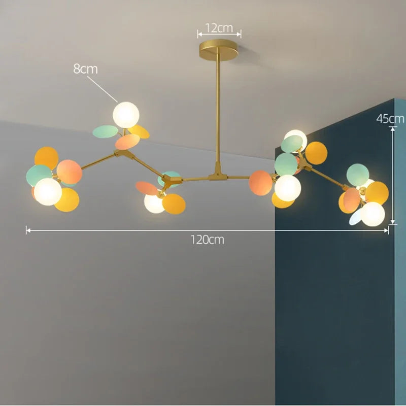 A modern led chandelier with gold-toned branches and colorful spherical and leaf-shaped light sources