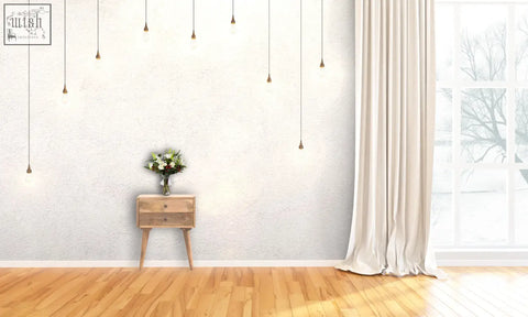 A delicate white and green flower bouquet sits on a modern solid wood bedside table in light wood finish
