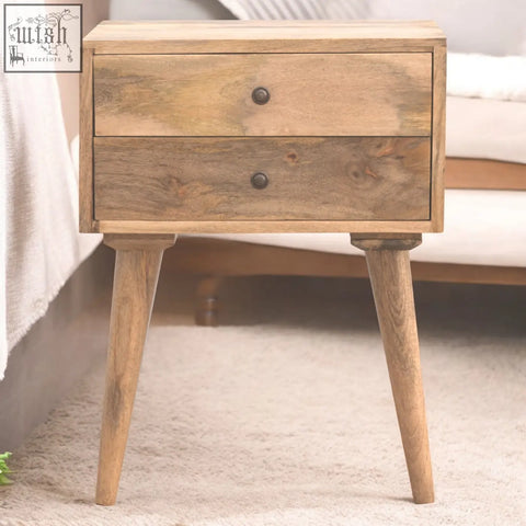A rustic solid wood bedside table with two drawers and dark metal knobs on tapered legs for modern bedroom use