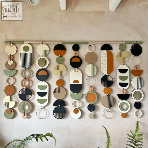 Modern wall art featuring layered wooden and metal circles and ovals in earthy tones for minimalist home decor