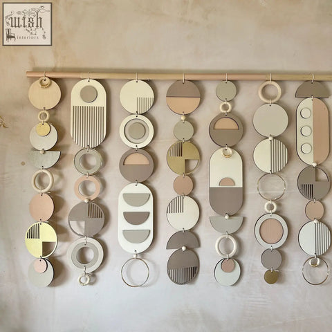 Modern wall art featuring layered wooden discs in beige, taupe, and cream with minimalist geometric patterns for decor