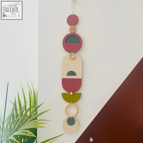A modern wall art piece with layered circular shapes in terracotta sage olive cream and natural wood tones