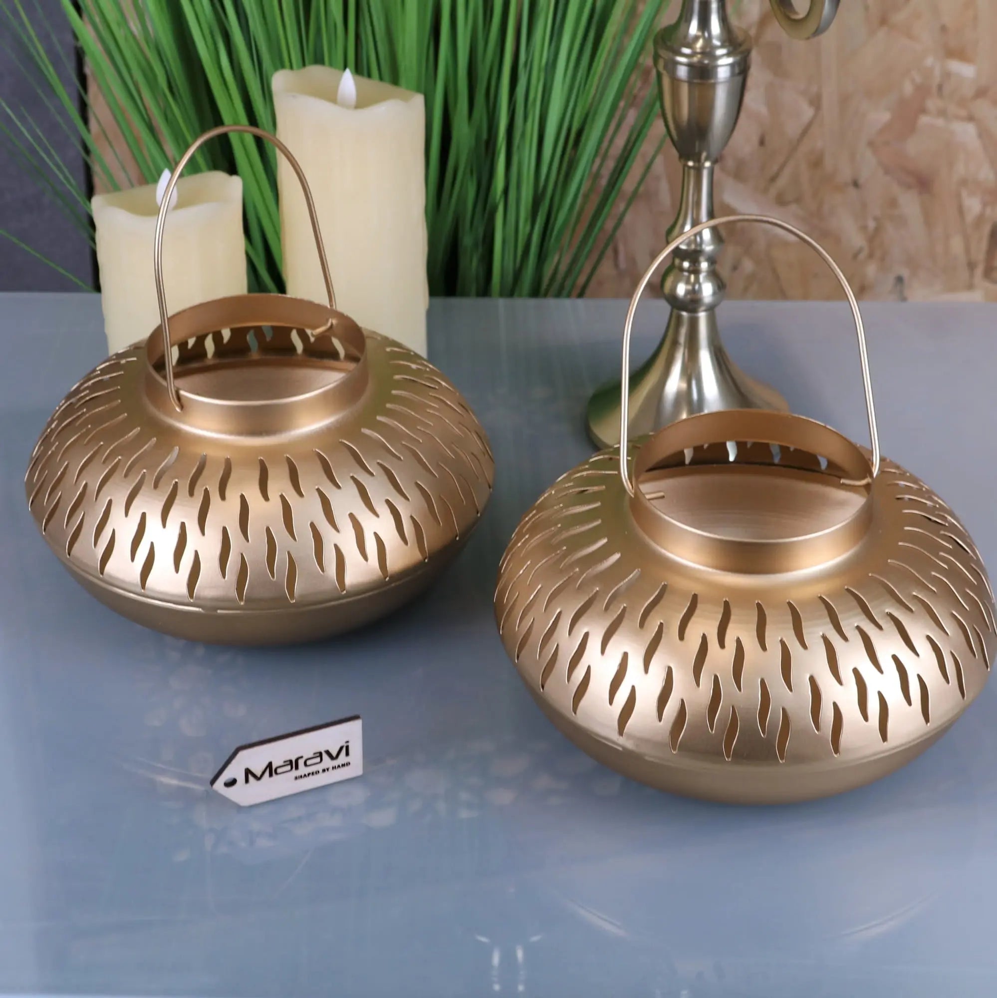 Two golden metal mohra gold candle lanterns with textured perforated design and curved handles for cozy lighting