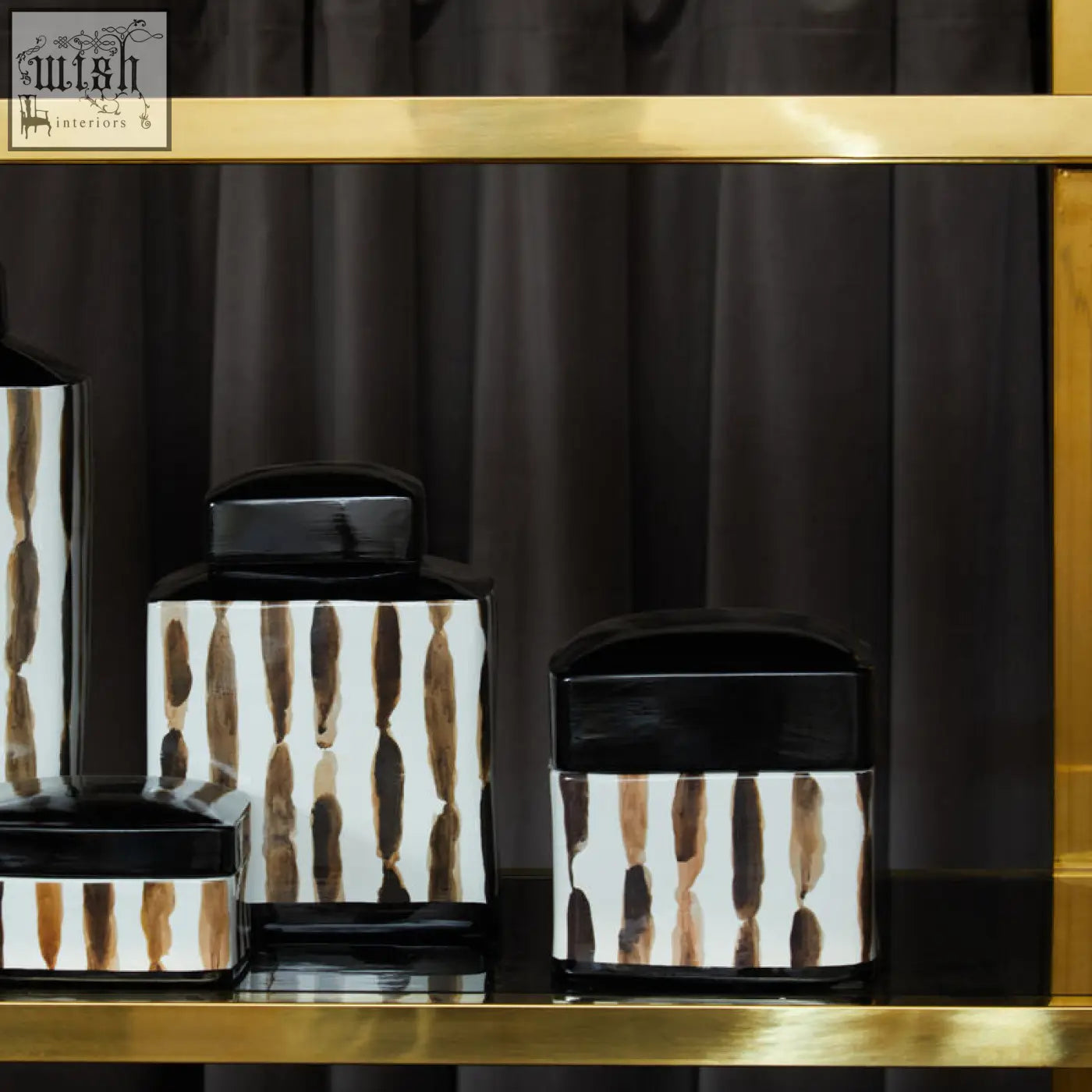 Set of four modern ceramic mona brushstroke trinket boxes with black lids and brown brushstroke patterns on a gold shelf