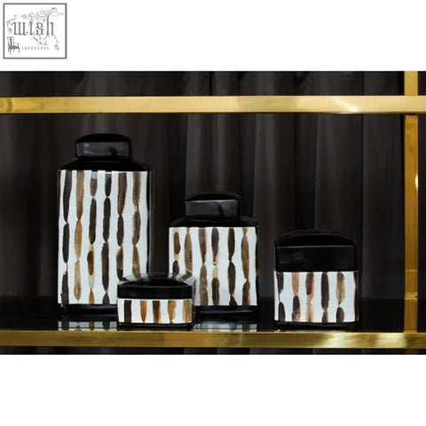 Set of four small ceramic jars with black lids and vertical brown and white striped patterns for kitchen storage