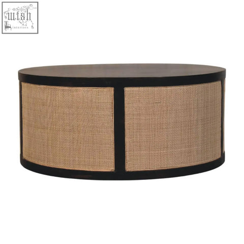 Black oval coffee table with dark wood top and woven cane sides featuring monaco round rattan panels storage bench