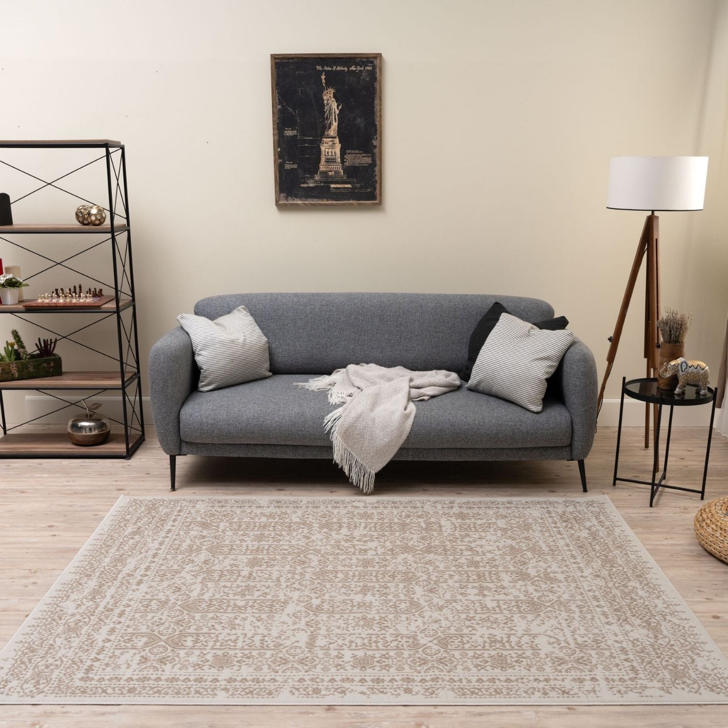 Gray upholstered sofa with striped pillows and a textured throw blanket on montana cream and beige rug 3716cb