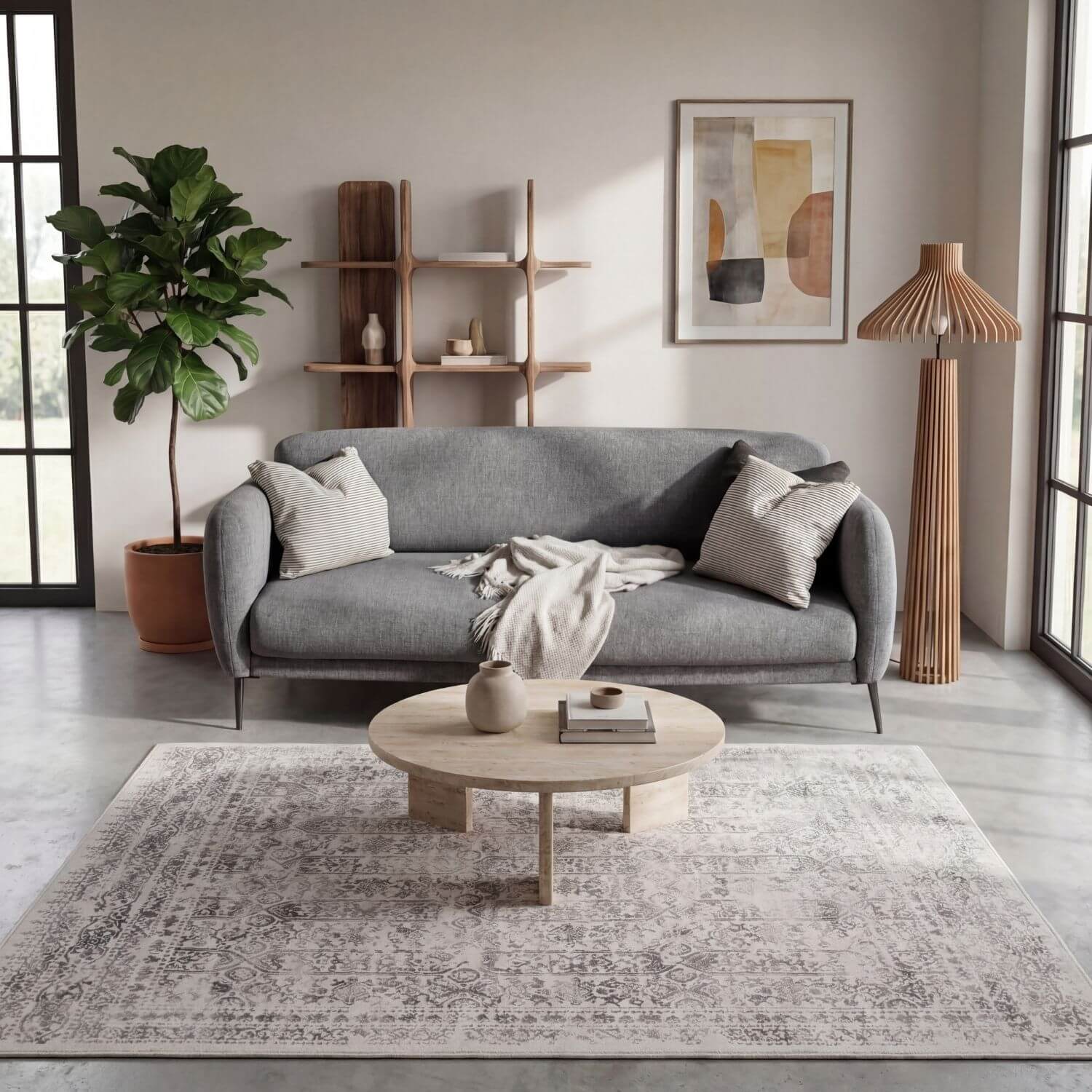 Gray fabric sofa with striped throw pillows and a blanket paired with a cream rug from the montana cream collection