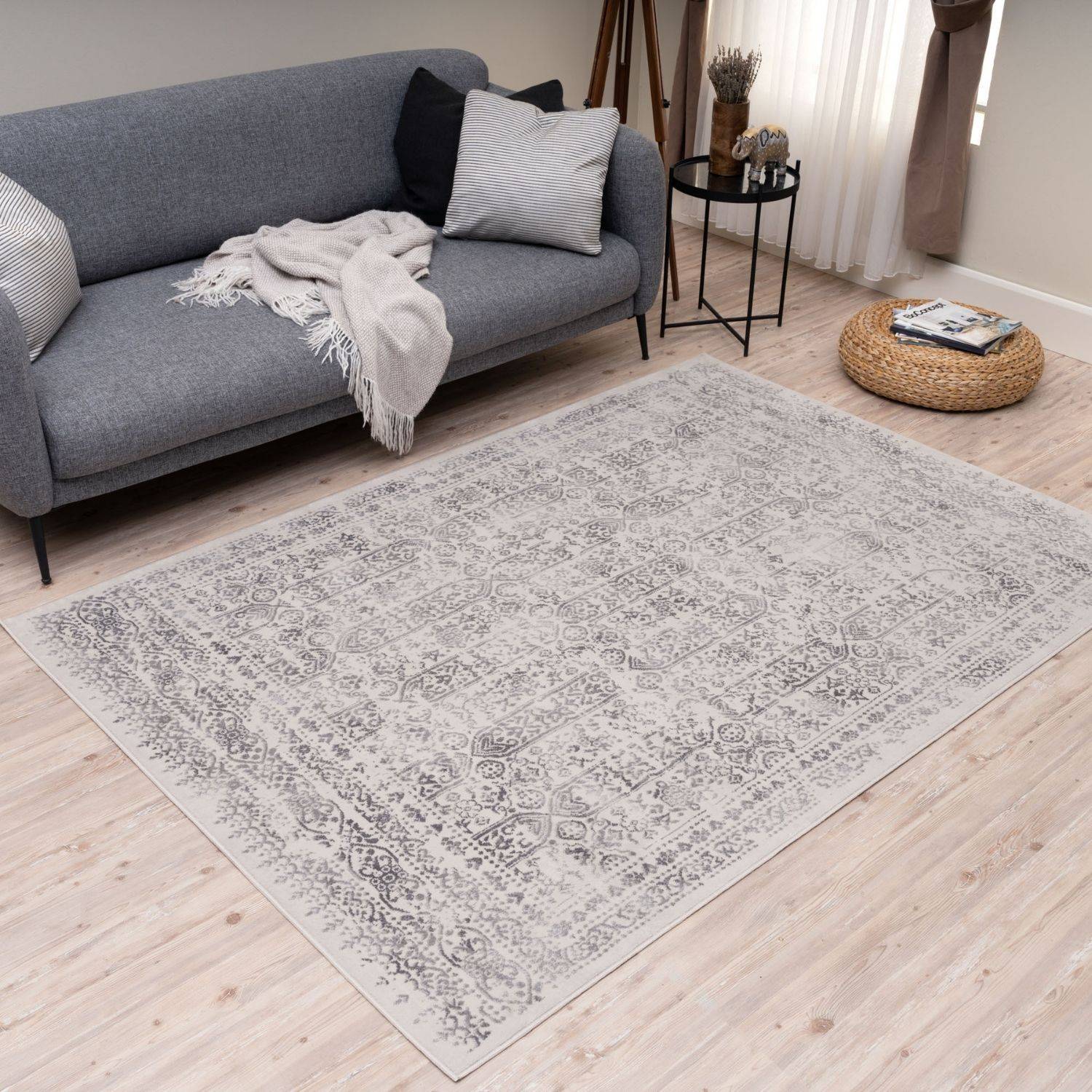 A rectangular vintage-style montana cream rug with a faded gray and white patterned design