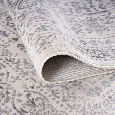 A montana cream rug with a soft off-white base and subtle gray vintage-inspired pattern with stitched edge
