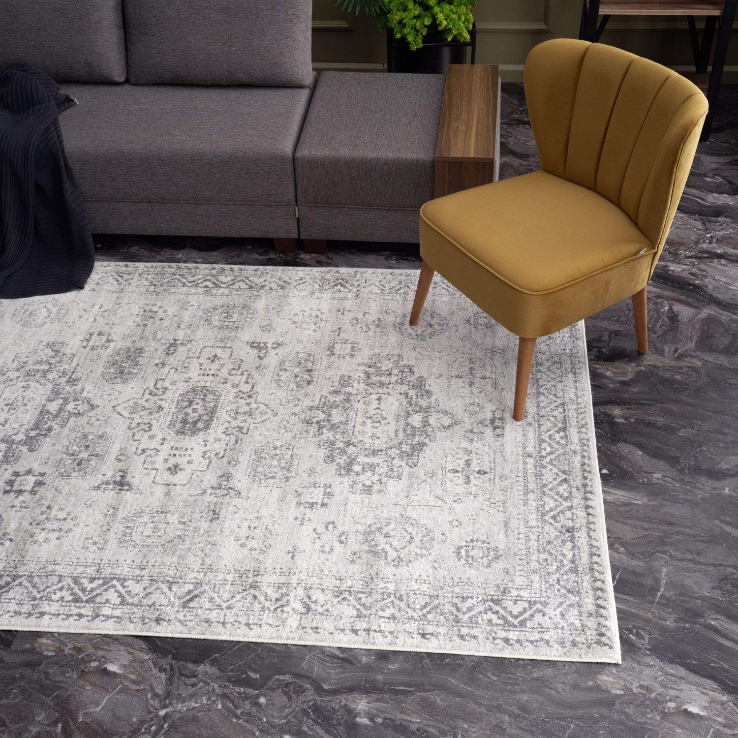 A montana vintage grey rug with a faded intricate geometric and floral pattern in shades of grey on off-white background