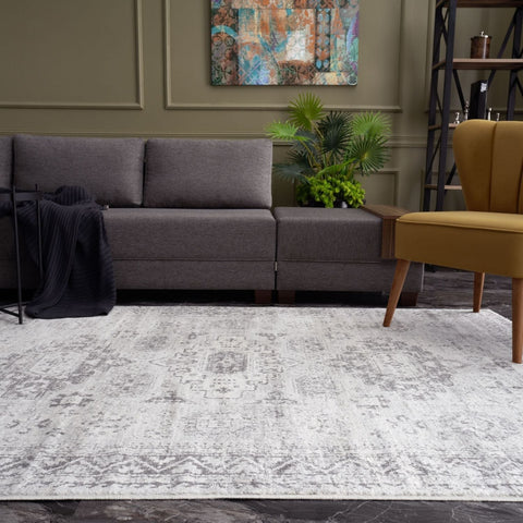 A montana vintage grey rug featuring a faded intricate geometric and floral pattern in shades of gray and white