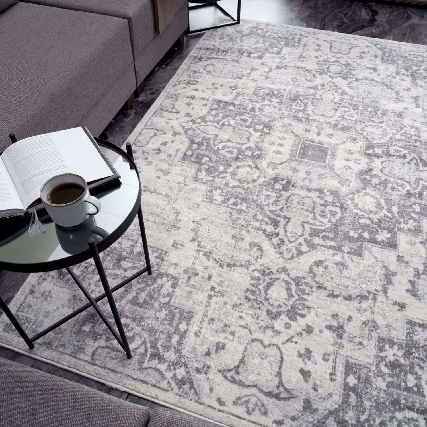 A vintage grey montana vintage area rug with gray and white intricate faded floral patterns perfect for living rooms