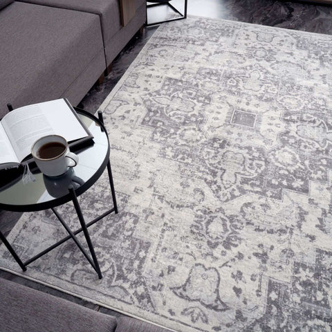A vintage grey montana vintage area rug with gray and white intricate faded floral patterns perfect for living rooms