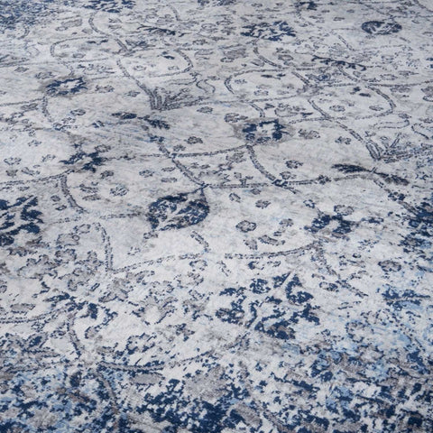A montana vintage navy area rug with a distressed blue and gray floral pattern on a light background
