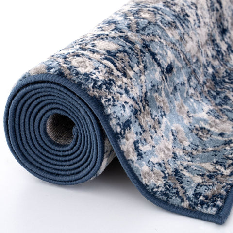 A rolled-up montana vintage navy rug with a distressed blue and beige plush pile and solid navy border