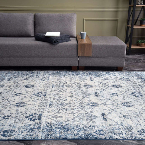 A montana vintage navy area rug with distressed blue and cream floral pattern and intricate geometric design