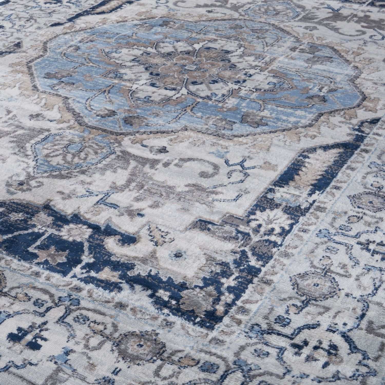 Antique-style montana vintage navy area rug with faded blue and gray floral medallion on off-white background