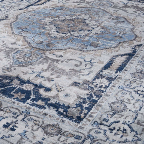 Antique-style montana vintage navy area rug with faded blue and gray floral medallion on off-white background