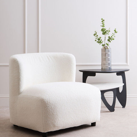 Montreal ivory boucle effect armless lounge chair with plush white faux fur and rounded cushioned design on black legs