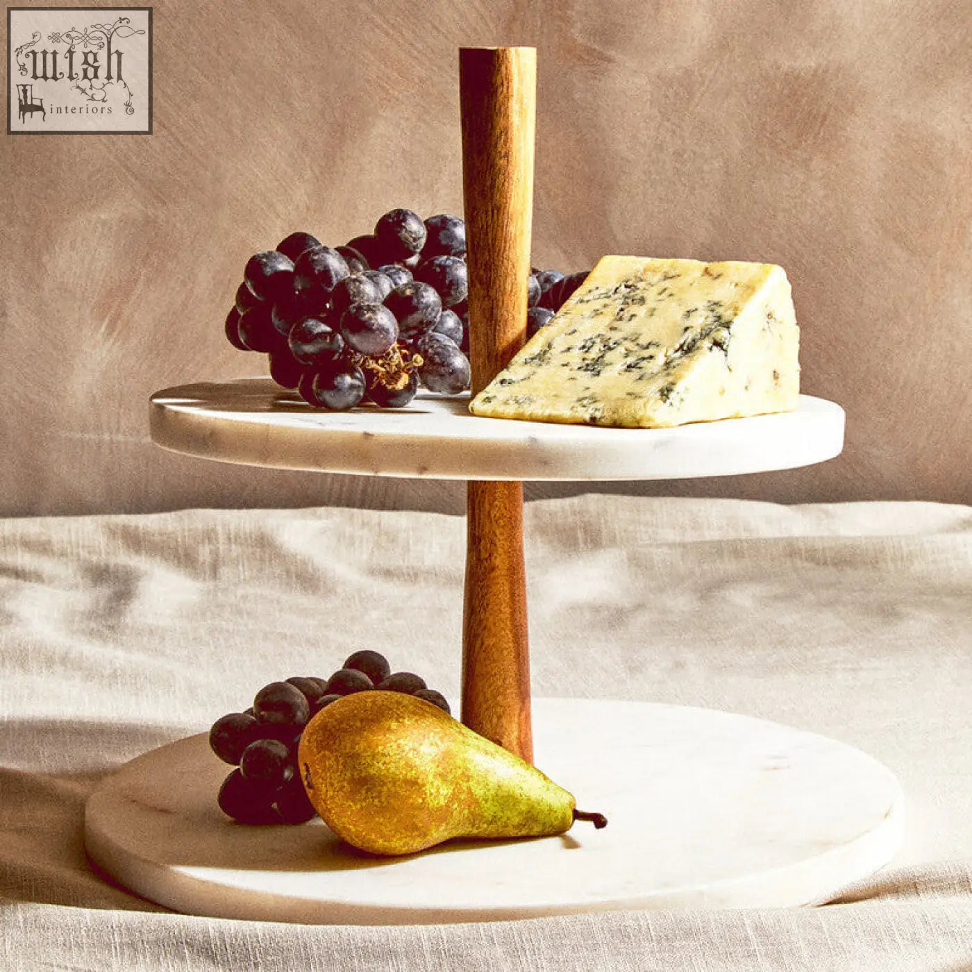 Two-tiered marble and acacia wood cake stand with wooden central column perfect for serving cheese and fruit