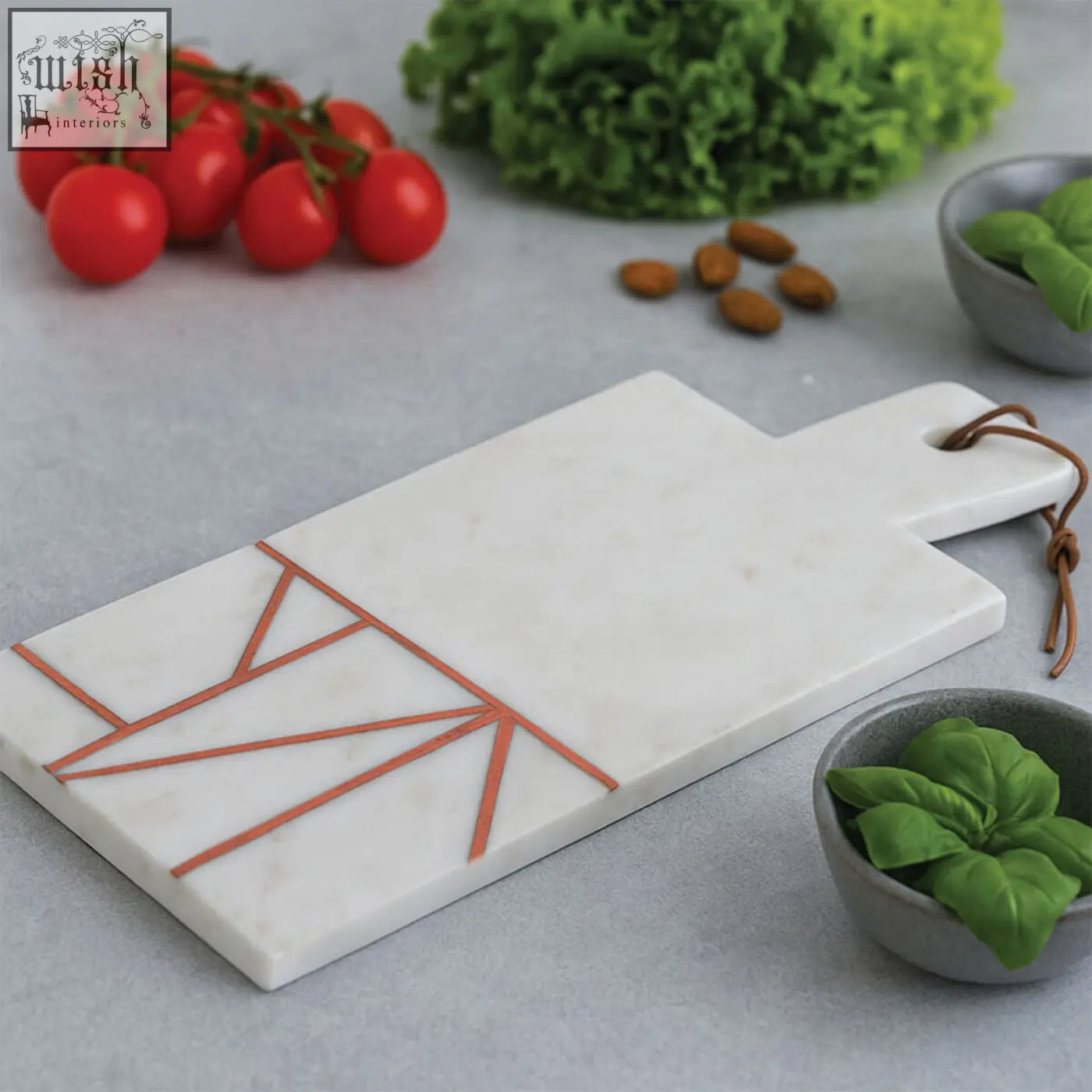 White marble cutting board with geometric copper inlay and leather tie handle from monzaro white marble collection