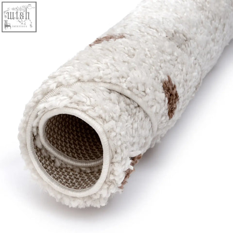 A plush moodi shaggy cream rug with brown paw prints soft texture and woven backing perfect for cozy spaces