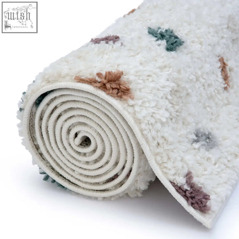A plush off-white moodi shaggy multicolour jubile rug with soft textured tufts in dusty rose and sage green tones