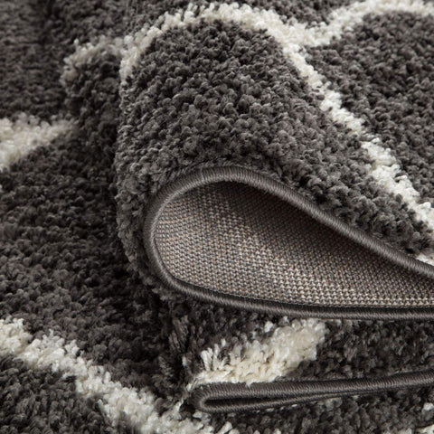 A plush moroccan dark grey shaggy rug with a modern geometric pattern in dark grey and off-white colors