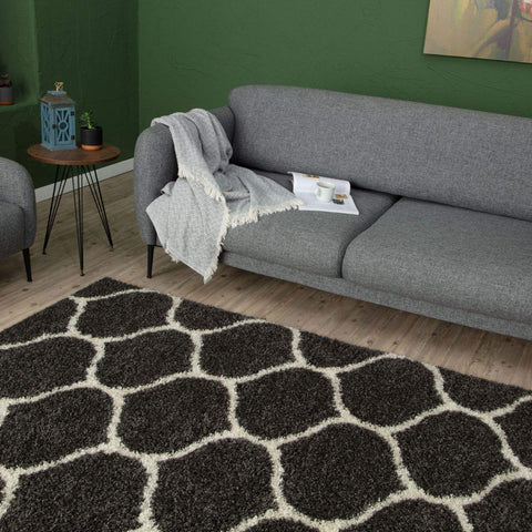 A plush moroccan dark grey shaggy rug with a black and white geometric pattern and soft texture