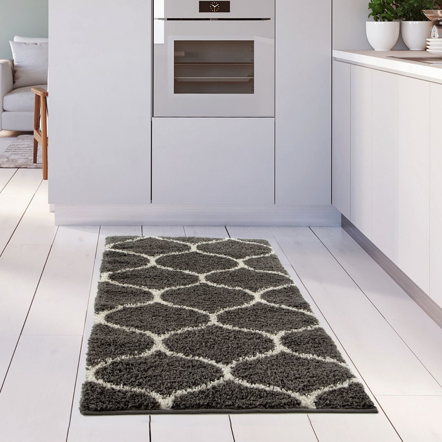 A plush moroccan dark grey shaggy kitchen rug with a gray and white geometric pattern and soft texture