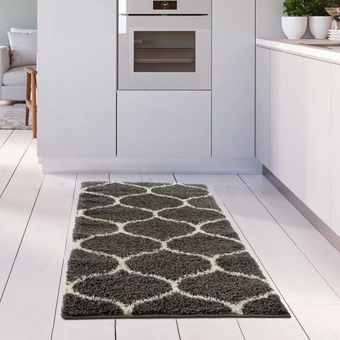 A plush moroccan dark grey shaggy kitchen rug with a gray and white geometric pattern and soft texture