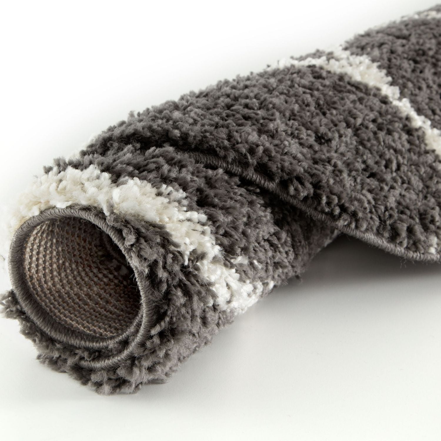 A plush rolled-up moroccan dark grey shaggy rug with a soft textured surface perfect for cozy spaces