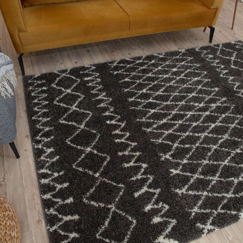A plush moroccan dark grey shaggy rug with a black and white geometric pattern for cozy living spaces