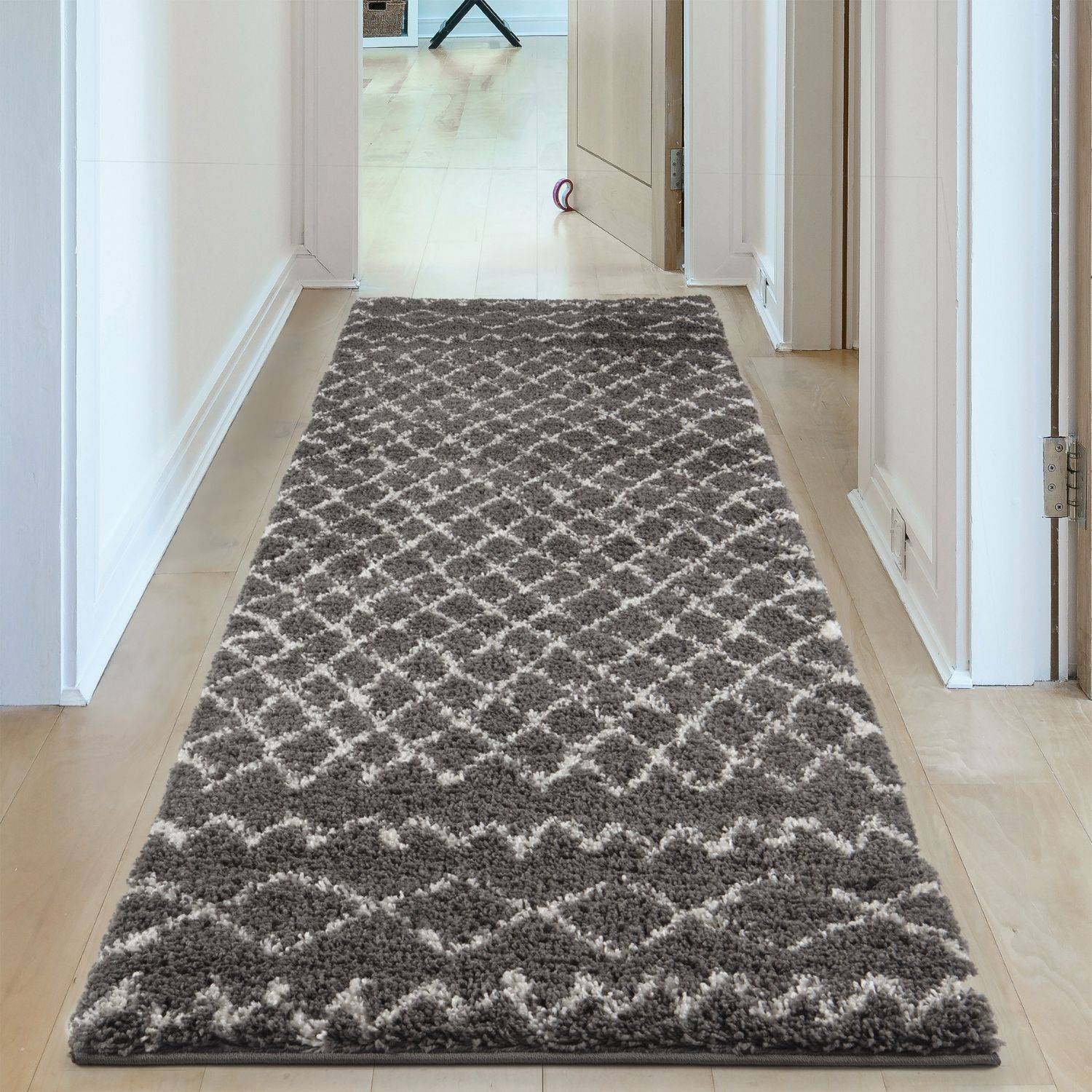 A plush moroccan dark grey shaggy rug with a gray and white geometric pattern perfect for hallways
