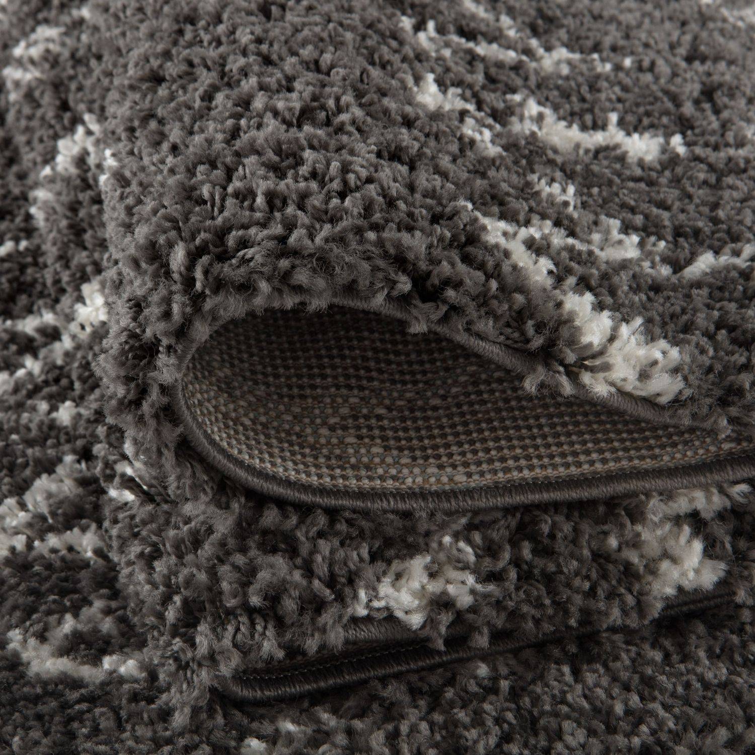 A plush moroccan dark grey shaggy rug with a textured grey and white pattern perfect for cozy spaces