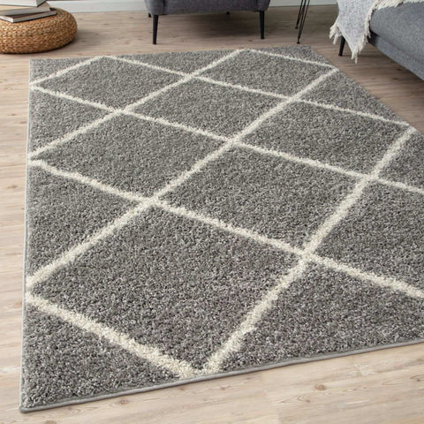 Moroccan grey shaggy area rug with a grey shaggy texture and geometric diamond pattern outlined in cream yarn